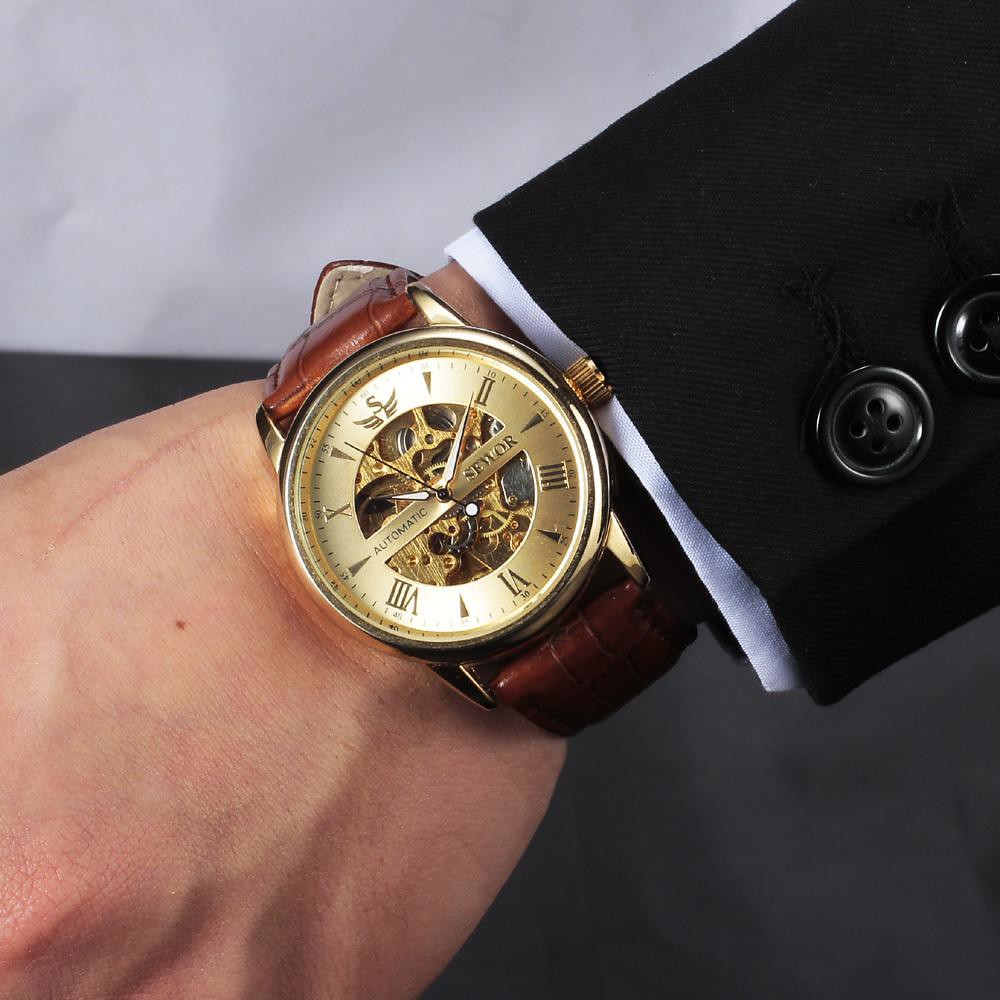 gold luxury watch on man's hand skeleton dial