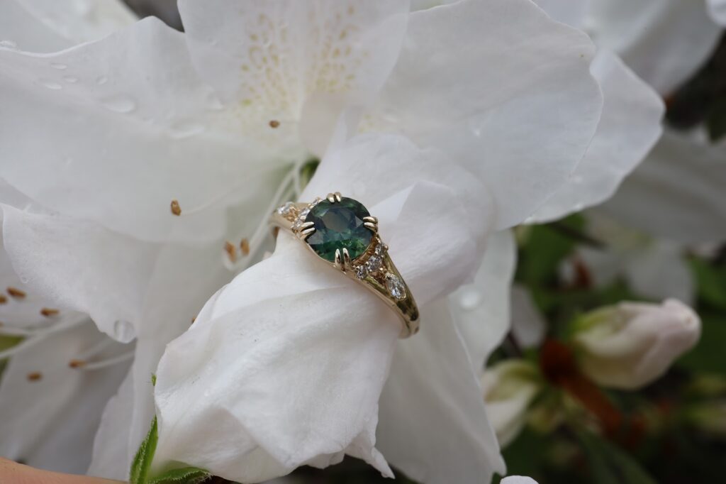 green diamond round cut custom engagement ring with white diamonds in yellow gold double prong engagement ring