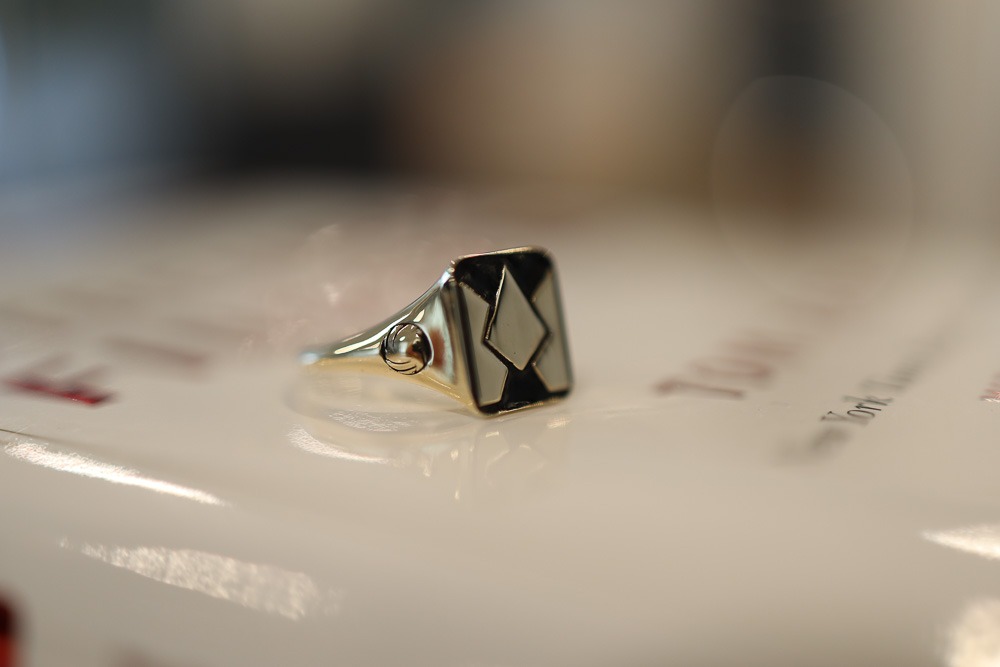 Refined monogram on signet ring.